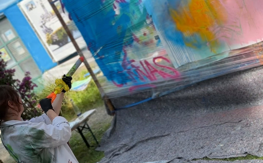 Teilnehmende dosieren beim GKM-Sommertag Farbe mit einer Spritze auf eine Leinwand im Botanikum München