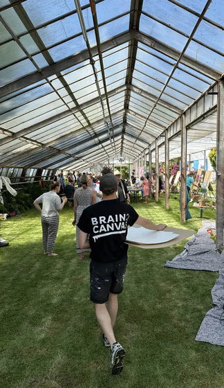 Team von GKM malt barfuß auf Rasen im Gewächshaus des Botanikums München