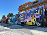 Teilnehmende einer Street-Art-Tour für Teams gehen gemeinsam durch München von Motiv zu Motiv