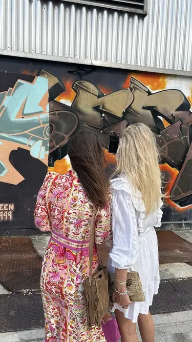 Zwei Personen fotografieren mit dem Handy ein gro&szlig;es Lettering-Motiv auf dunkler Wand